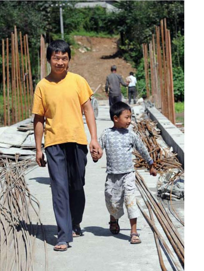 Liu Hongwei of Yuemuyuan village crosses the new bridge with his son. (Photo taken by Benny Lo)