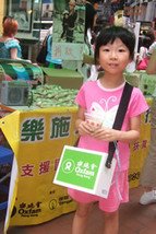 In Hong Kong, volunteers sold Oxfam Rice to raise funds for the Sichuan earthquake. This girl volunteered with her mother and father in Causeway Bay.
