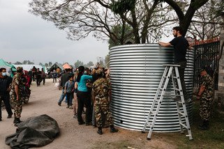 乐施会正在灾区展开首阶段的救援工作，向灾民提供紧急物资，包括清洁食水、临时厕所，以及为灾民搭建临时居所等。图为乐施会救援队伍在Tundikhel 营地设置容量达1.1万公升的储水缸，确保灾民有清洁的水源。(摄影: Aubrey Wade / Oxfam)