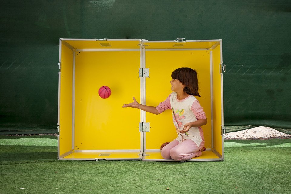 A child playing inside a yellow box..